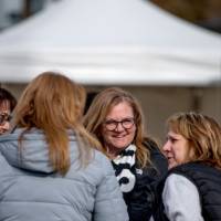Four alumni laugh together at the Tailgate